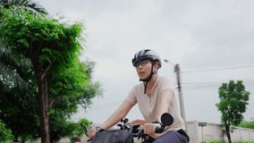 Young Asian woman helmet checking her smartwatch while cycling outdoors. - Powered by Shutterstock - Get 15% off with code: PIKWIZARD15