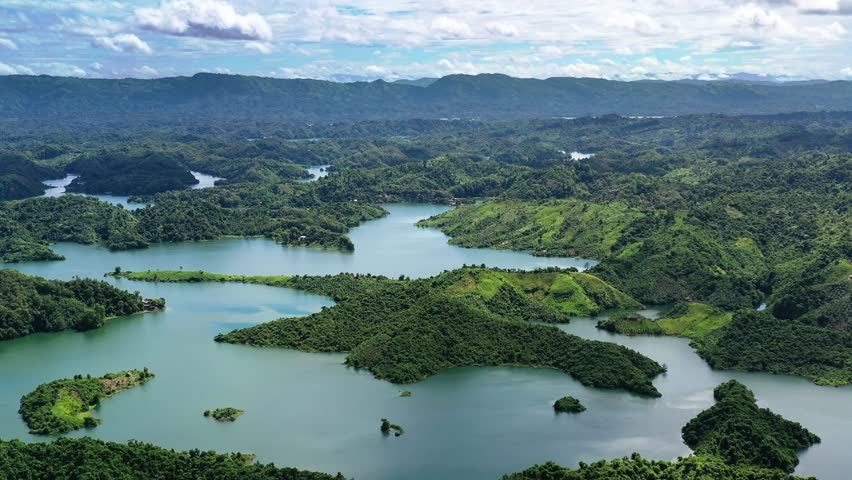 Aerial view of Kaptai Lake surrounded by lush green hills, creating a stunning contrast between the water and the vibrant landscape, Rangamati, Chittagong Division, Bangladesh.