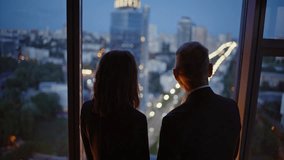 Silhouettes two business people looking night cityscape from high-rise office building closeup. Elegant businesswoman showing something to senior businessman. Confident partners talking by window. - Powered by Shutterstock - Get 15% off with code: PIKWIZARD15