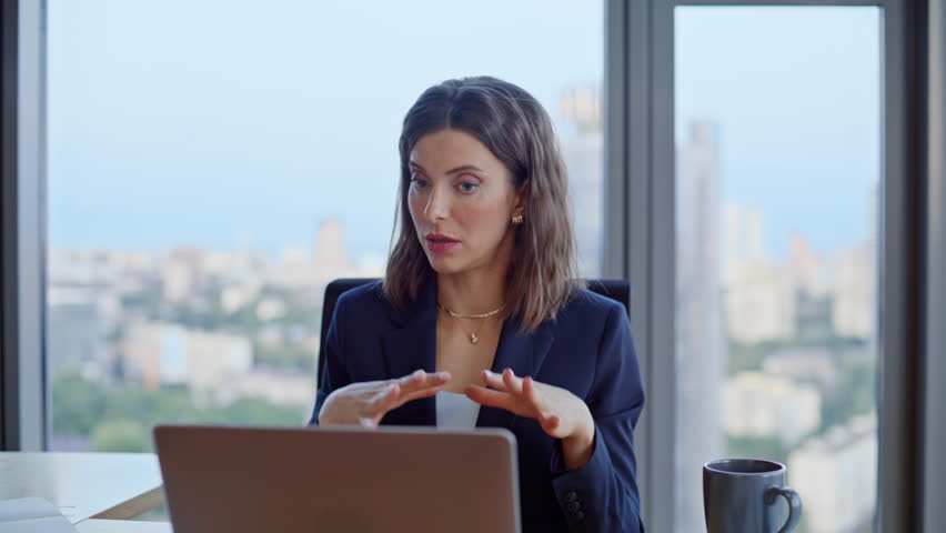 Businesswoman conducting virtual meeting with partners talking in laptop webcam closeup. Serious woman entrepreneur discussing project at video conference. Elegant lady have internet call in office.