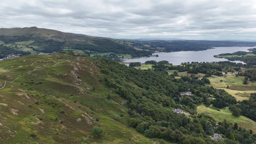 Aerial drone footage capturing sweeping views over Loughrigg Fell in the Lake District on a clear summer’s day.