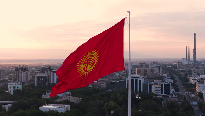 Closeup Of Kyrgyzstan Flag Waving With The Wind At Sunrise In Bishkek, Kyrgyzstan. - aerial shot