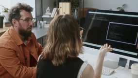 Male and female programmers trying to solve problem with codes together while sitting at desk in front of computer - Powered by Shutterstock - Get 15% off with code: PIKWIZARD15