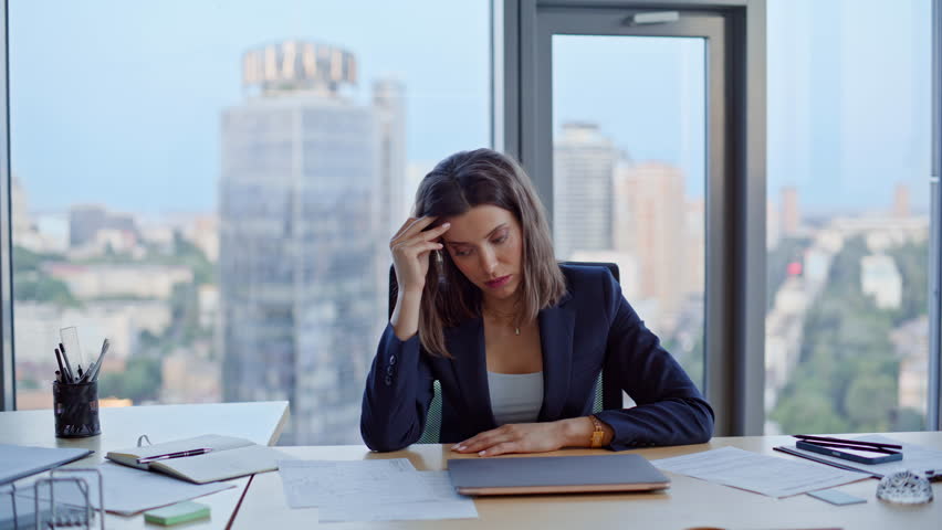 Anxious business lady thinking on project issues sitting modern office high-rise building closeup. Stressed businesswoman worried financial crisis at workspace. Overwhelmed woman executive feeling sad