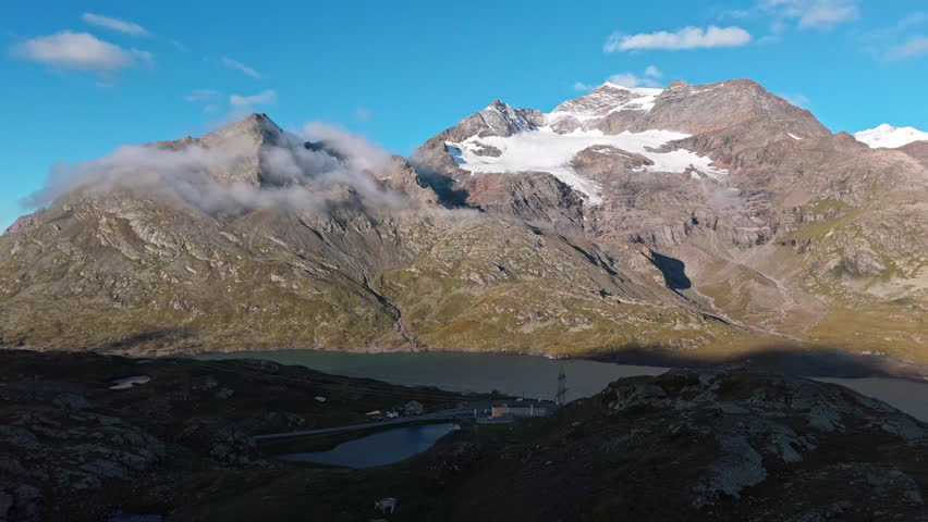 Scenic mountain pass with lake, clouds, and peaceful landscape