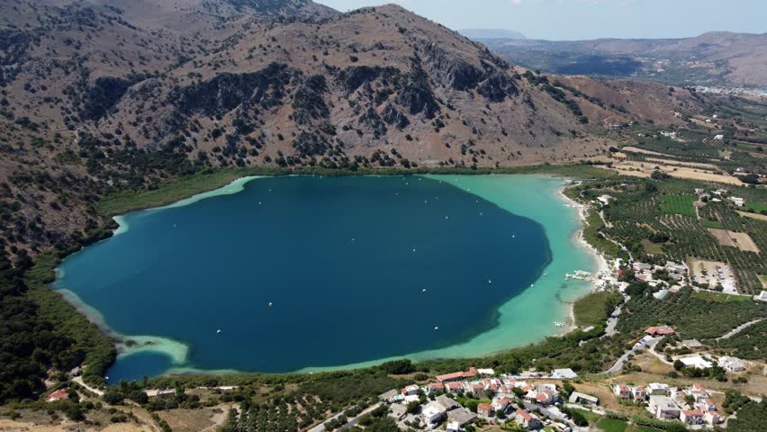 Kournas freshwater turquoise lake in Crete and Kournas mountainous village, Drone shot