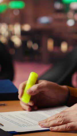 Vertical Video Elderly student using highlighter pen to memorize lesson papers, applying a study strategy with essential information from courses. Old man works on memorization for exams. Camera B.
