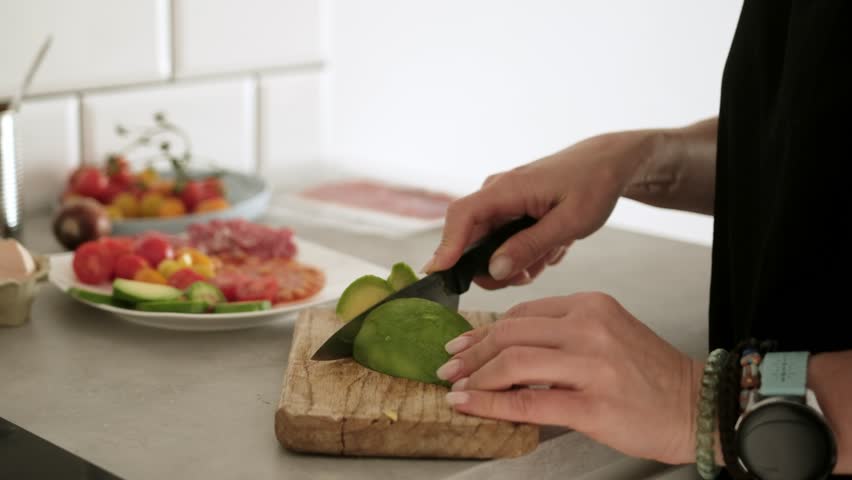 Woman Slices Avocado And Prepares Breakfast Close-Up