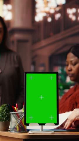 Vertical Video Focused diverse people studying in public library with green screen on pc, researching educational materials and reading. Using library resources for coursework and school exams. Camera