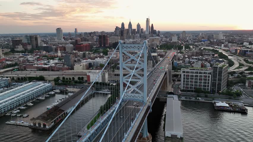 Marina pier and jetty near benjamin Franklin bridge in Philadelphia at sunrise. Traffic scene with cars driving to downtown of America. Metropolis. Skyline and skyscrapers in background. PA, U.S