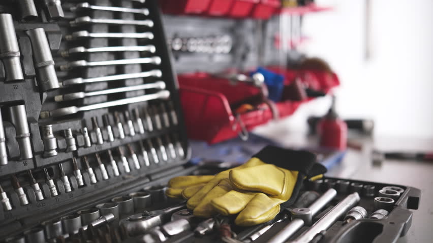 Mechanic's Workbench With Tools, Wrenches, And Gloves In The Auto Repair Shop