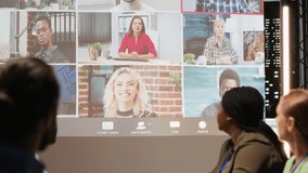 Diverse coworkers joining a video conference with international stakeholders, gathering in boardroom for a late night meeting. Business associates pitch proposals for project development. Camera B. - Powered by Shutterstock - Get 15% off with code: PIKWIZARD15