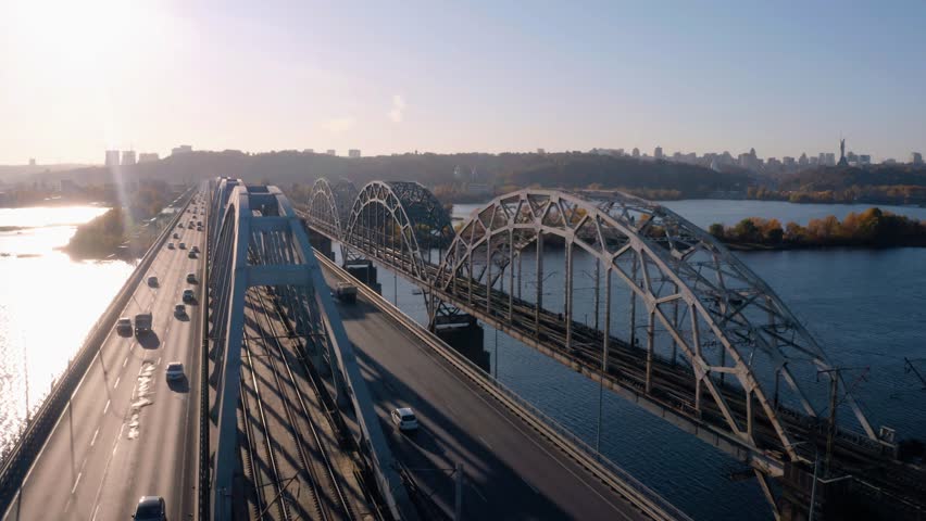 Aerial view of the bridge and the road with cars traffic over the river. Modern city skyline on a summer day. Kiev, Ukraine.