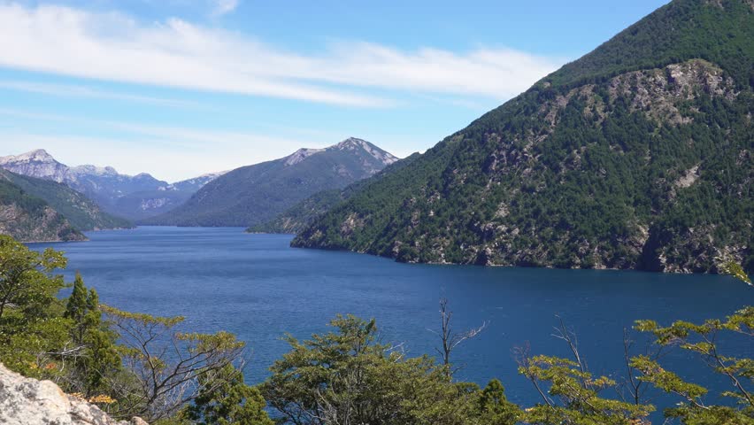 Zoom-In View of Brazo de la Tristeza in Bariloche with blue waters, forested slopes and Andean peaks in Nahuel Huapi National Park, Argentina.
