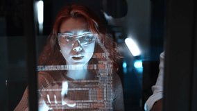 Female programmer is coding a hologram at night, working on data analytics, information technology, malware, or software at the office. Staff developer work in a computer display in  problem solving. - Powered by Shutterstock - Get 15% off with code: PIKWIZARD15