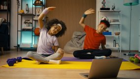 Two African American children watching online fitness tutorial, copying exercise - Powered by Shutterstock - Get 15% off with code: PIKWIZARD15