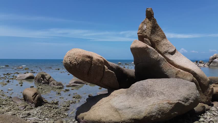 Aerial drone footage of Lamai Beach in Koh Samui, Thailand, featuring turquoise ocean, rocky shoreline, tropical island horizon, and scenic coastal landscape under clear tropical skies.