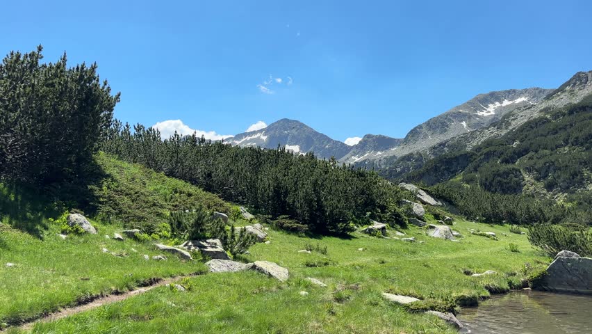 Beautiful alpine lake surrounded by the Pirin Mountains in Bulgaria. Tranquil water and scenic wilderness landscape.