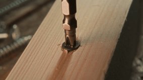 Detailed close up view of unrecognizable woodworker backing out screw from timber plank with drill during removal process - Powered by Shutterstock - Get 15% off with code: PIKWIZARD15