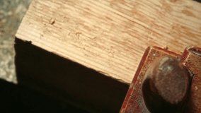 Close up view of hand of unrecognizable carpenter shaving wooden plank with planer, producing curled shavings on its surface during woodworking process - Powered by Shutterstock - Get 15% off with code: PIKWIZARD15