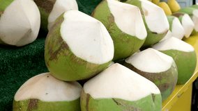 A close-up of fresh green coconuts with a blurred beach background of sand and waves. - Powered by Shutterstock - Get 15% off with code: PIKWIZARD15