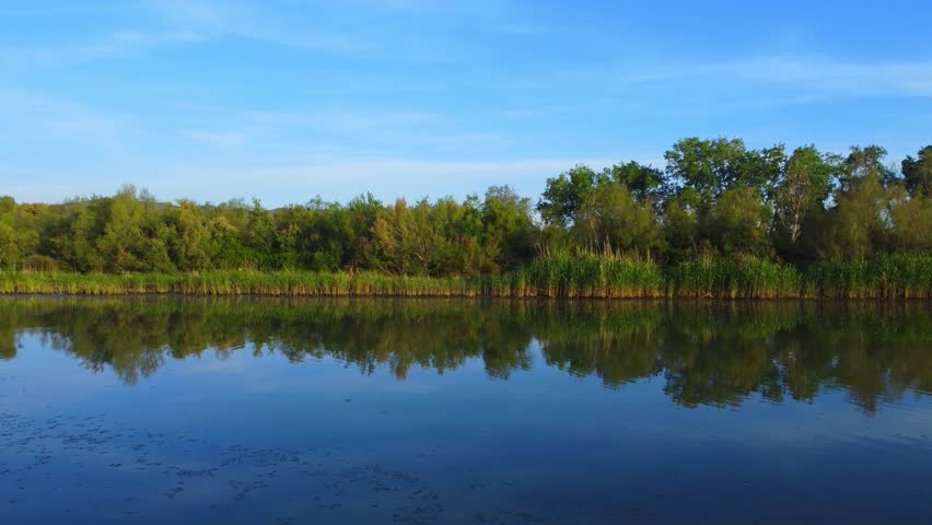 Beautiful landscape of lake and reflection of blue sky, clouds and mountains on surface of lake, Panoramic view of lake and snow-covered mountain and Forest trees calm in Jijel Algeria North African.
