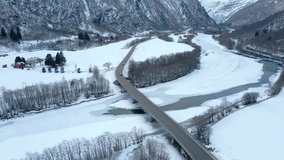 Aerial drone footage captures the serene winter beauty of the og Romsdal region in Norway. Snow-covered landscapes, a winding river, and a bridge crossin - Powered by Shutterstock - Get 15% off with code: PIKWIZARD15