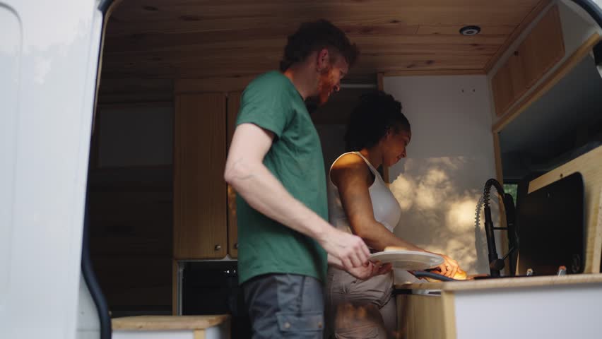 Couple cooking together in camper van kitchen