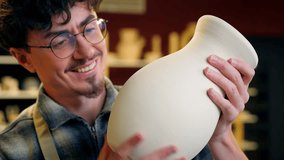 Caucasian man potter craftsman holding handmade clay vase male sculptor smiling satisfied guy male enjoy art work in pottery workshop artisan small business owner craft store sculpting ceramics jug - Powered by Shutterstock - Get 15% off with code: PIKWIZARD15