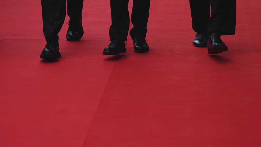 Red carpet with ropes and golden barriers on a luxury party entrance, cinema premiere film festival event award gala ceremony, wealthy rich guests arriving, outdoor decoration elements, summer day