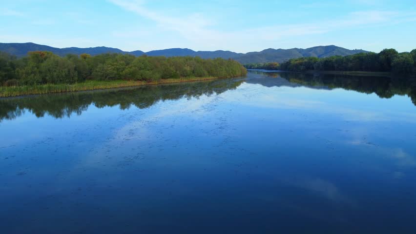 Beautiful landscape of lake and reflection of blue sky, clouds and mountains on surface of lake, Panoramic view of lake and snow-covered mountain and Forest trees calm in Jijel Algeria North African.