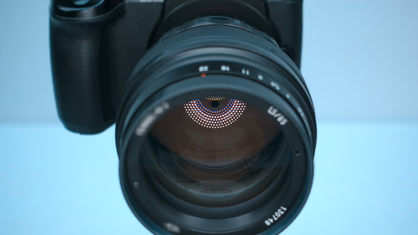 A professional camera on a tripod with an expensive lens with an aperture of 1.5 and a focal length of 85 mm, which reflects the ring LED light. Closeup. Macro. Shot in motion