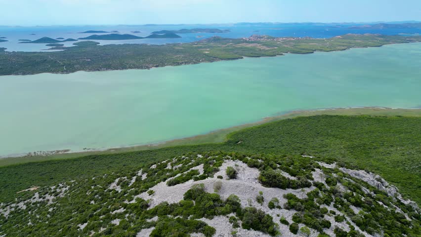 Panoramic view from Vidikovac Kamenjak, the highest point above Vransko Lake Nature Park in Croatia. The viewpoint offers breathtaking views of the Adriatic Sea, surrounding islands, and Dalmatia