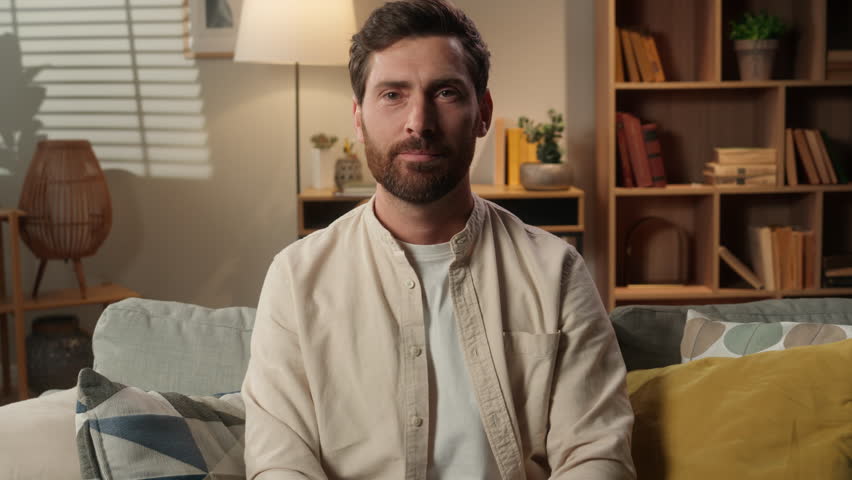 Caucasian man portrait at home casual living room smiling joyful male homeowner tenant freelancer businessman happy looking at camera thumb up recommend like gesture good excellent super approve sign