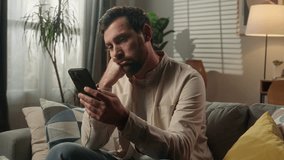 Sad upset frustrated man Caucasian businessman guy bored using mobile phone on couch sofa worried disappointed male homeowner reading news cellphone browsing message scam scrolling smartphone at home - Powered by Shutterstock - Get 15% off with code: PIKWIZARD15
