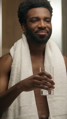 African American man drink glass of water at home bathroom healthy morning routine thirst smiling guy male drinking cold aqua refreshing habit balance h2o refresh health care hydration body moisturize