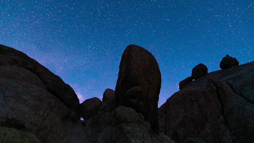 Timelapse tracking shot of Milky Way galaxy over boulders in Alabama Hills in California