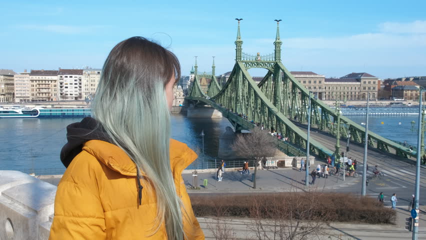 Feels disgust suffering from street. A young girl feel angry and suffer from busy street against budapest panorama in the sun light