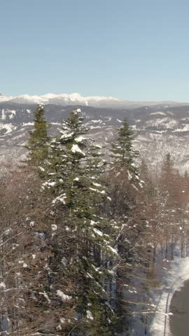 AERIAL: Picturesque drone view of a fog covered valley in the snowy Julian Alps. Flying around the snowy wilderness high in the backcountry of Slovenian mountains. Gorgeous alpine scenery from above.