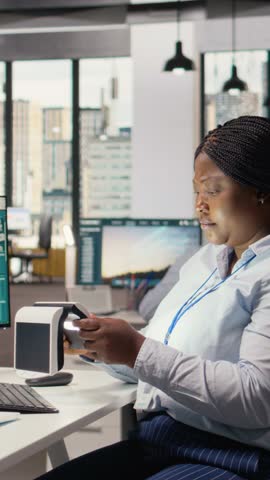 Engineer in office testing innovative solar powered device, turning lights on. RD expert doing trial of portable solar panel gadget to improve environmental conservation efficiency, camera A