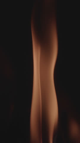 Slow-motion footage of firewood burning vividly with bright orange flames dancing against a pitch-black background, creating a stunning and primal visual ideal for cinematic, atmospheric, or natural f