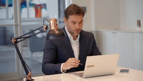 Mature businessman adjusts glasses to focus on digital screen, sitting in modern office with laptop. Concept of work concentration, business data analysis, and online communication.  - Powered by Shutterstock - Get 15% off with code: PIKWIZARD15