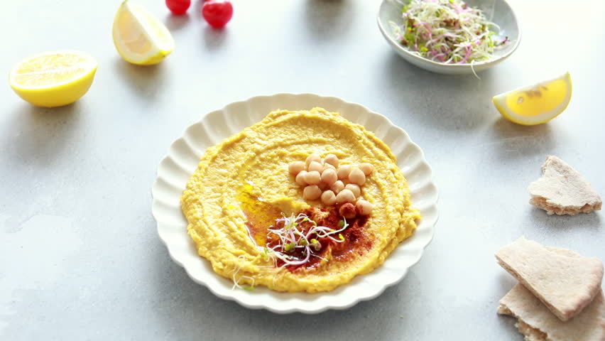 Female hands pick up a dish of pumpkin hummus. Autumn pumpkin recipes