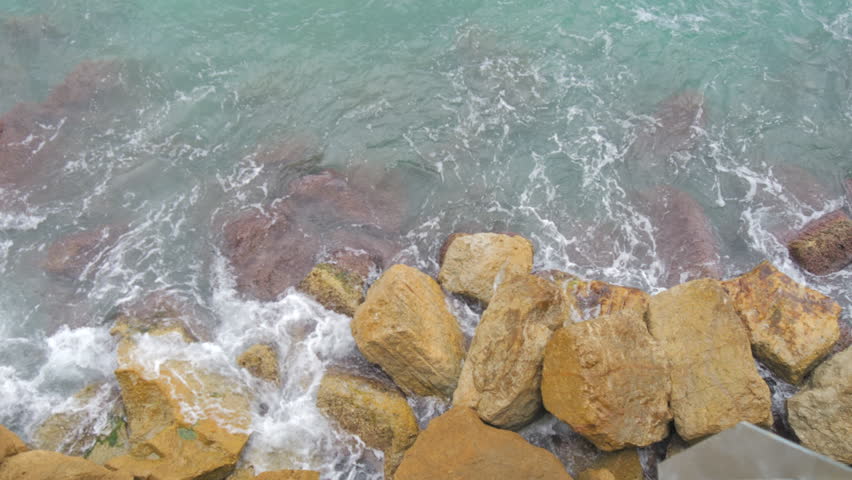Slow Motion Waves Crashing Against Rocky Shoreline