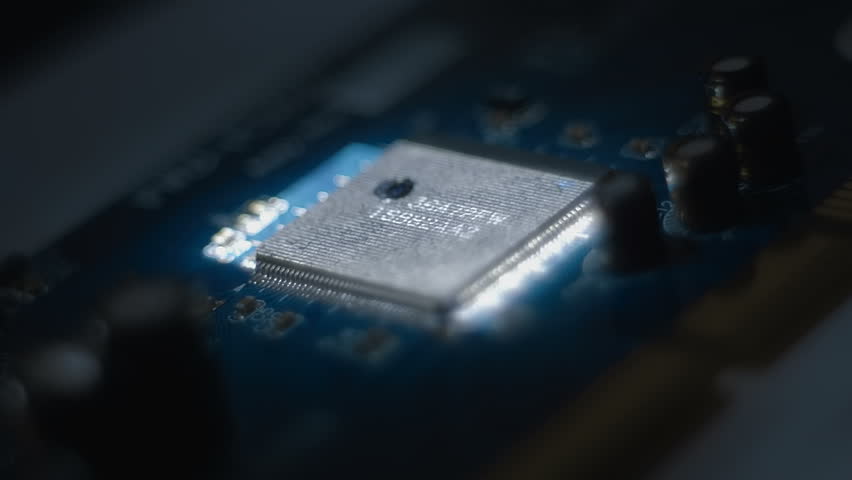 Lines of program code moves on a microchip in a circuit board, symbolizing the operation of an electronic device. Closeup. Macro. Follow focus. Shallow depth of field - Powered by Shutterstock - Get 15% off with code: PIKWIZARD15