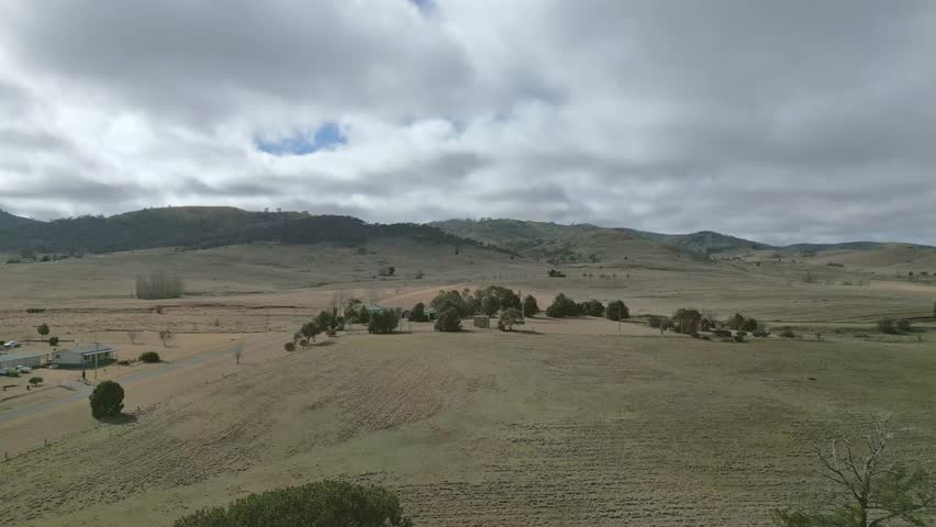 Lifting high above the pastures and fields to reveal rolling hills.