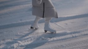 Close-up of a girl's legs in white skates glide over the ice. Skating on a lake in sunshine. Winter activities, leisure time. - Powered by Shutterstock - Get 15% off with code: PIKWIZARD15