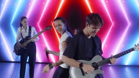 Young musicians playing instruments and singing on neon lit stage, generating electrifying energy with passionate performance by guitarist, singer, and bass player - Powered by Shutterstock - Get 15% off with code: PIKWIZARD15