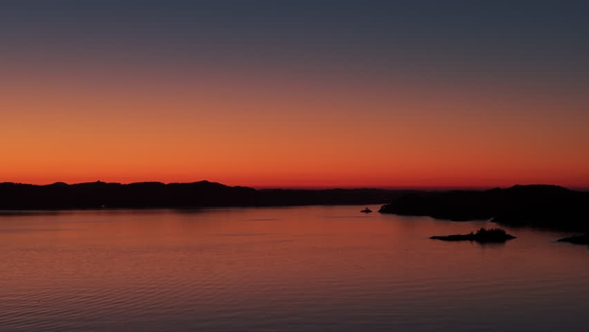 Aerial panorama of the Norwegian coast, bathed in the warm afterglow of sunset