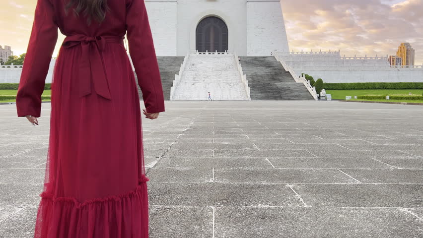Asian woman walks in the Archway of Chiang Kai Shek Memorial Hall, Tapiei, Taiwan. The meaning of the Chinese text on the archway is "Liberty Square".